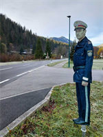 ein Mann in Uniform, der auf einer Straße mit einer Straße und Bäumen steht